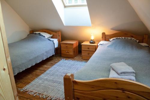 um quarto no sótão com 2 camas e uma janela em Gungas em Adazi