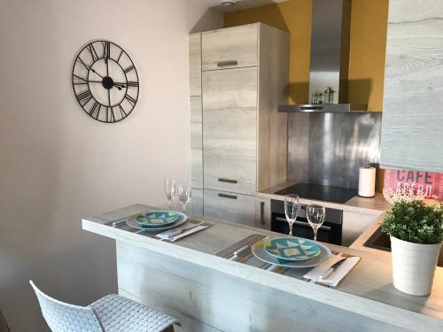 a kitchen with a table with plates and wine glasses at La Villa Soregia in Lattes