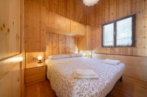 a bedroom with a bed in a wooden cabin at Casa Bucaneve in Barzio