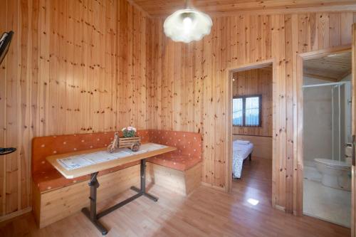 Habitación de madera con banco y mesa. en Casa Bucaneve en Barzio