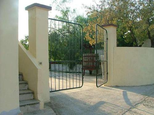 a gate to a house with stairs and a table at Agriturismo Tenuta La Siesta in Gallipoli