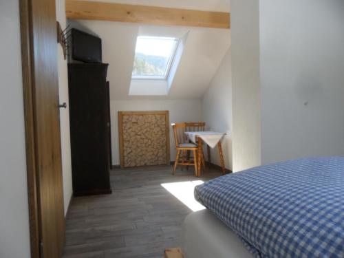 a bedroom with a bed and a table and a window at Berggasthof Pechhäusl in Berchtesgaden