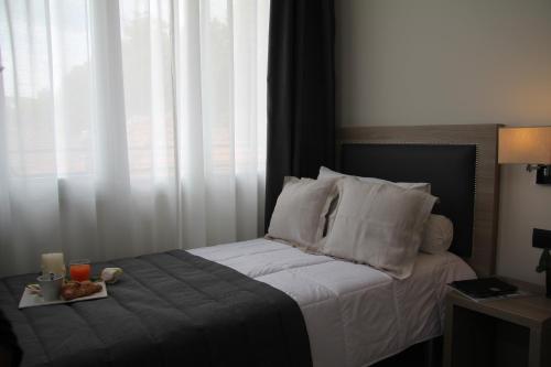 a bedroom with a bed with a tray of food on it at Hotel Zara Milano in Milan