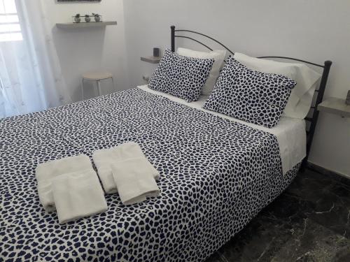 a black and white bed with two towels on it at Panoramic View Atlas Loutraki in Loutraki