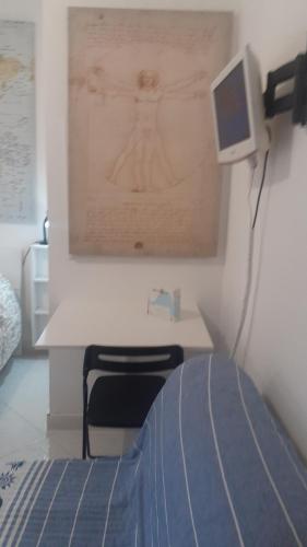 a bedroom with a desk with a computer on the wall at La Casa di Berenice a Porto Azzurro in Porto Azzurro