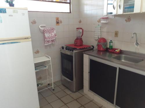 a small kitchen with a stove and a sink at Casa de Praia Veraneio in Maceió