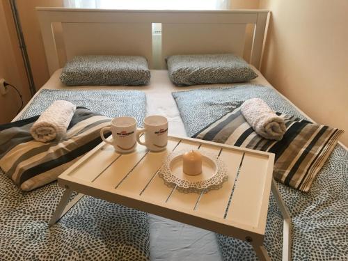 1 cama con mesa con 2 almohadas y 1 cama con mesa en Tudor Apartman, en Szeged