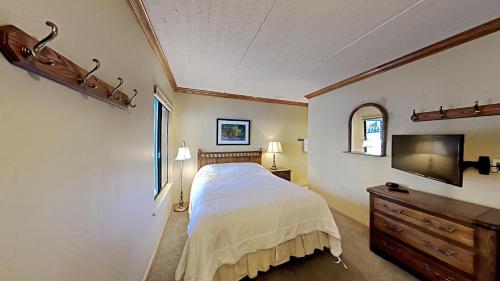 a bedroom with a bed and a flat screen tv at Lakeview 826 Condo #108 Condo in Mammoth Lakes