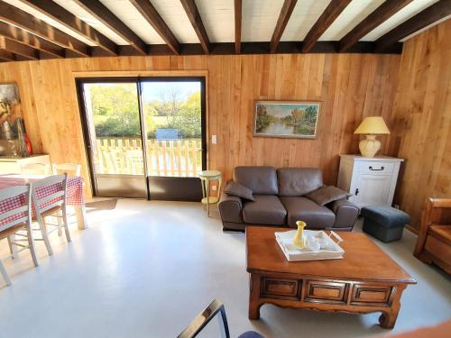 a living room with a couch and a table at Chalet au bord d'un lac privé in Saint-Estèphe