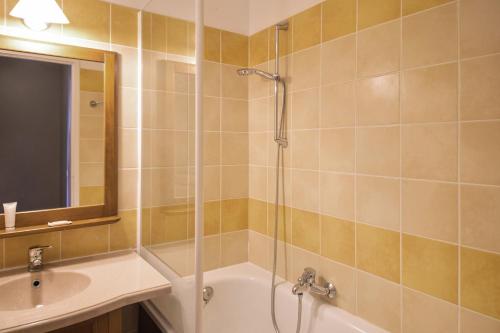 a bathroom with a shower and a tub and a sink at Residence du Lac - maeva Home in Monflanquin