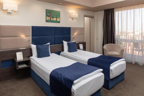 una stanza d'albergo con due letti e una sedia di Belfort Hotel a Braşov