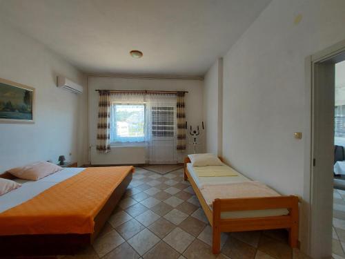 a bedroom with two beds and a window at Apartments Bernarda in Krk