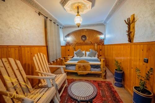 una camera con un letto e due sedie in legno di Mount Toubkal Lodge a Imlil