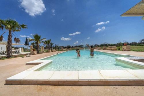 two people are playing in a swimming pool at Villa Salux by HDSalento in Taurisano