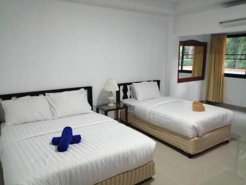 a bedroom with two beds with blue shoes on them at มุก&พลอย เรสซิเดนซ์ in Sattahip