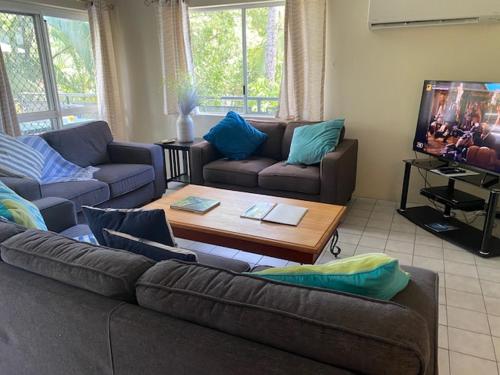 uma sala de estar com um sofá e uma mesa de centro em Marina Terraces Port Douglas em Port Douglas