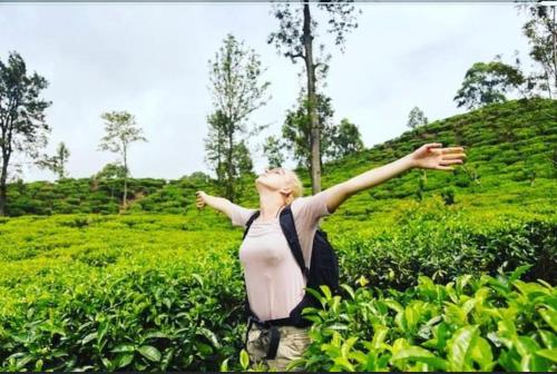 a woman standing in a field with her arms outstretched at Bandarawela luxurious villa in Bandarawela