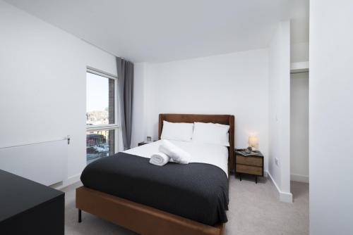 A bed or beds in a room at Modern Studios and Apartments at Barking Wharf in London