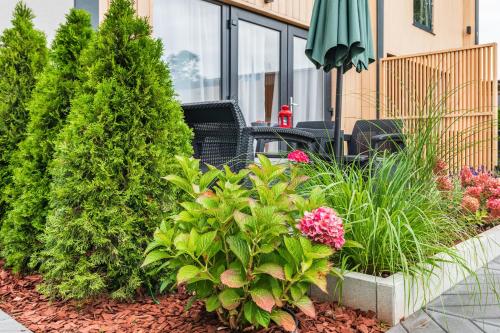 a garden with flowers and plants in front of a building at Holiday Point in Międzywodzie