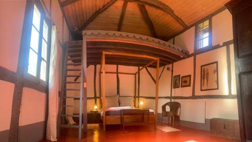 une chambre avec un lit et un escalier en colimaçon dans un bâtiment dans l'établissement Maison Magnolia, à Onesse-et-Laharie