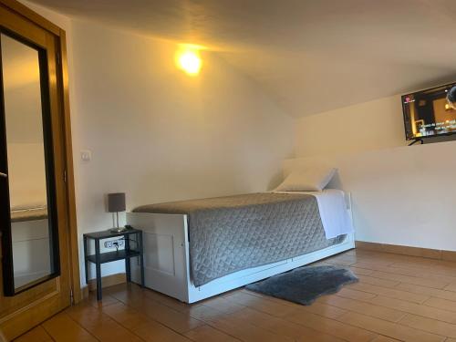 a bedroom with a bed in the corner of a room at Vissaium Rooms in Viseu