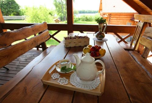 a table with a tea pot and fruit on a porch at Apartamenty Osowa nad jeziorem Okmin in Suwałki