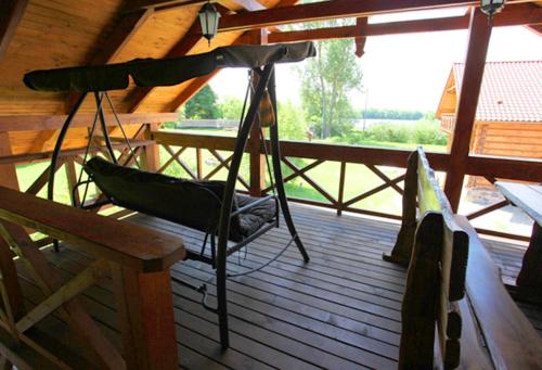 a hammock on the deck of a cabin at Apartamenty Osowa nad jeziorem Okmin in Suwałki