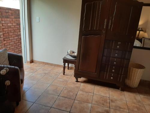 a living room with a cabinet and a tiled floor at Acacia Gastehuis in Kathu