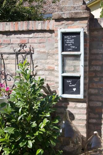 a window in a brick building with a sign in it at Bíborlak in Villány