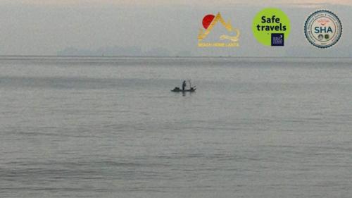 a small boat in a large body of water at Beach Home Lanta in Ko Lanta