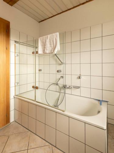 a bathroom with a tub with a glass shower at Hofgut Wiggenweiler in Bermatingen