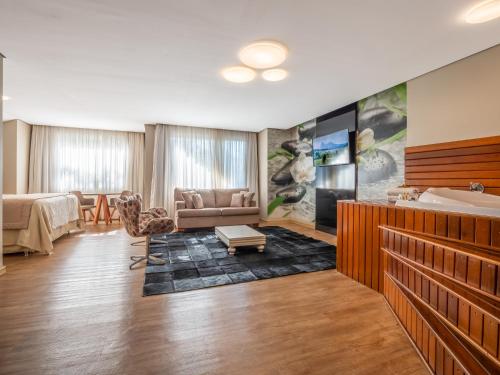 a hotel room with a bed and a couch at Hotel Refugio da Montanha in Gramado