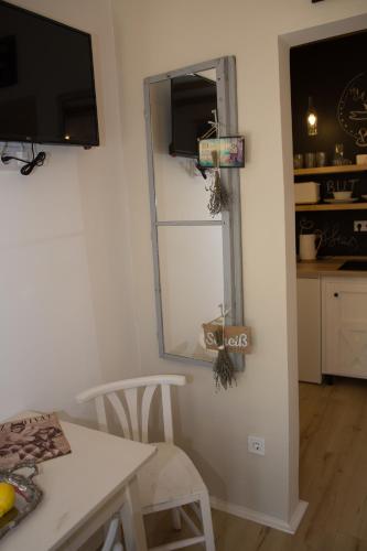 a dining room with a table and a mirror and a kitchen at Bíborlak in Villány