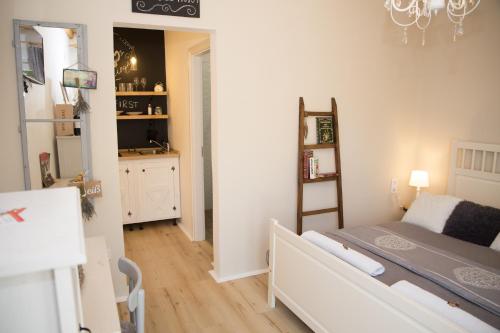 a small bedroom with a bed and a kitchen at Bíborlak in Villány