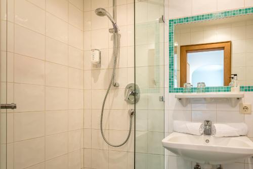 a bathroom with a shower and a sink at Hotel Garni Gästehaus Brand in Bad Wiessee