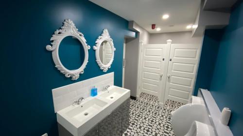 a bathroom with a white sink and two mirrors at The Imperial Garvagh in Garvagh