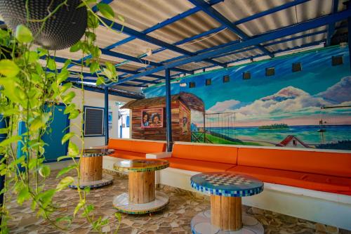 um quarto com um sofá e dois bancos e um mural em Alojamiento San Martín em San Andrés