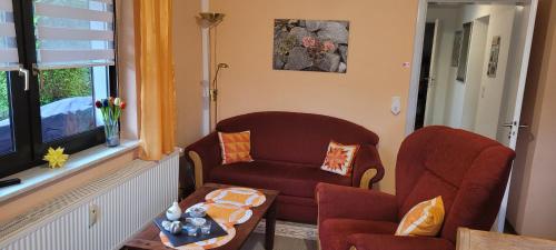 a living room with a red chair and a chair at FeWo Harz Haennig 1 in Wieda
