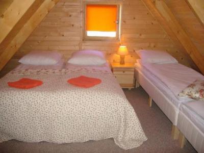 a bedroom with two beds in a wooden cabin at Domki letniskowe Katarzyna in Sarbinowo