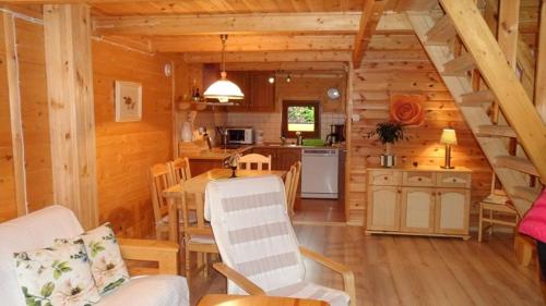 a dining room and kitchen in a log cabin at Domki letniskowe Katarzyna in Sarbinowo