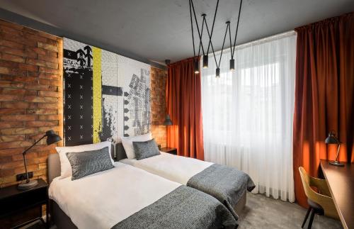 a bedroom with a bed and a brick wall at 7 Rooms Suites in Belgrade