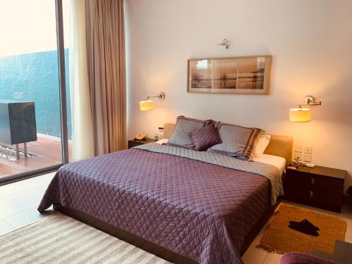 a bedroom with a bed and a large window at Luxury Goa Villa in Candolim