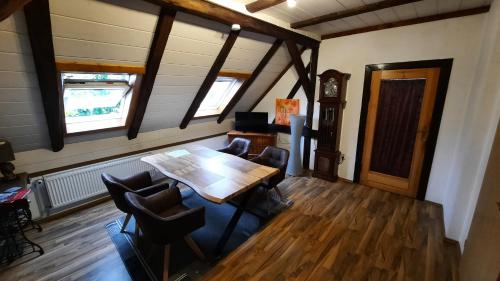 a room with a table and chairs and a clock at Zum Holzwurm in Mühlanger