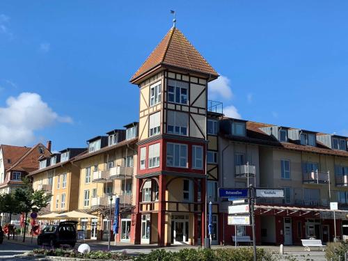 ein hohes Gebäude mit einem Uhrturm auf einer Straße in der Unterkunft FeWo Drei Moewen in Kühlungsborn