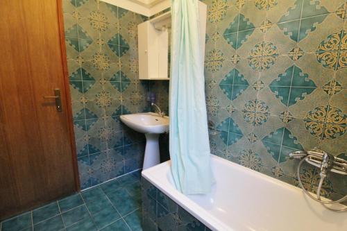 a bathroom with a sink and a tub and a shower curtain at Apartments Marija Savudrija in Savudrija
