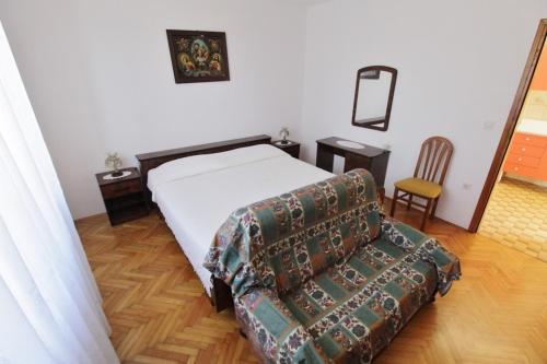 a bedroom with a bed and a couch and a chair at Apartments Marija Savudrija in Savudrija