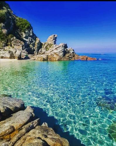 a view of a beach with rocks and the water at ZAMBRONE VILLAGE Loris in Zambrone