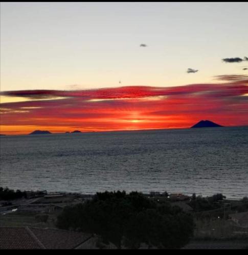 a sunset over a body of water with mountains in the background at ZAMBRONE VILLAGE Loris in Zambrone