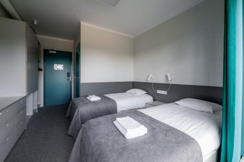 a room with two beds with towels on them at Kääriku Hostel in Otepää