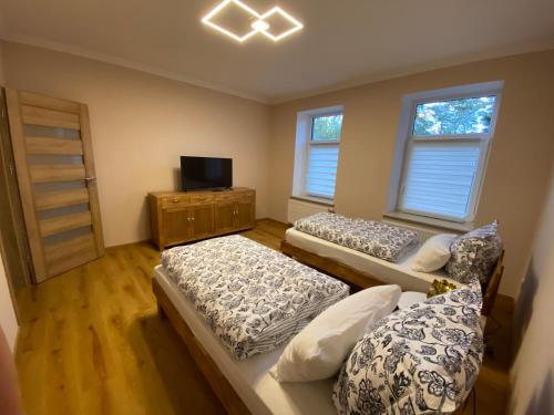 ボルナにあるSchöne 2 Raumwohnung in Bornaのベッド3台とテレビが備わる部屋